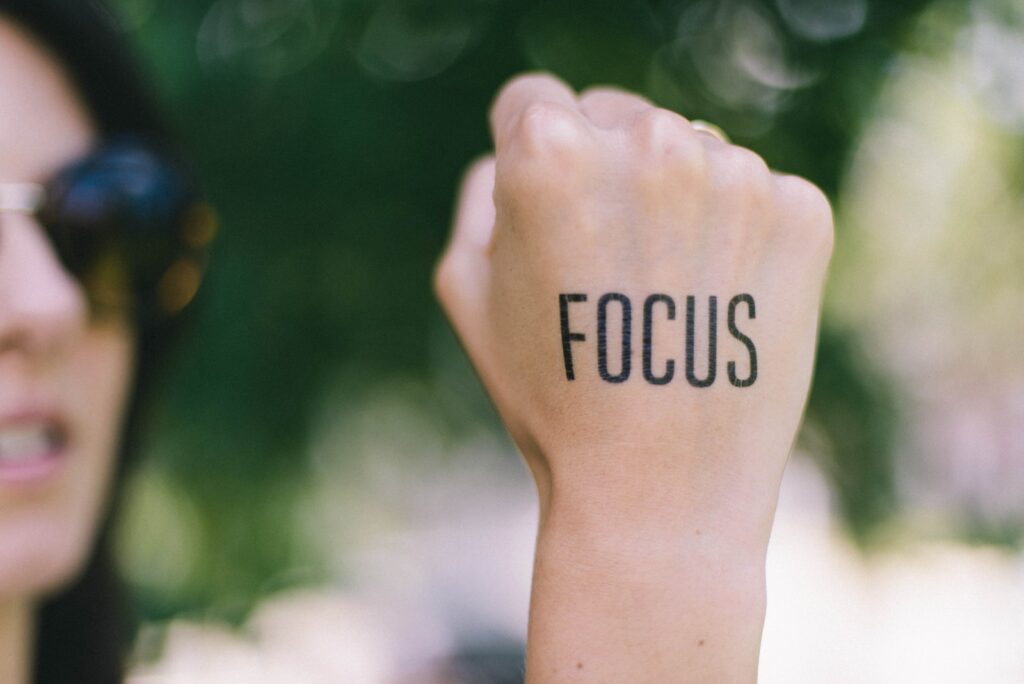woman right fist with "focus" tattoo
